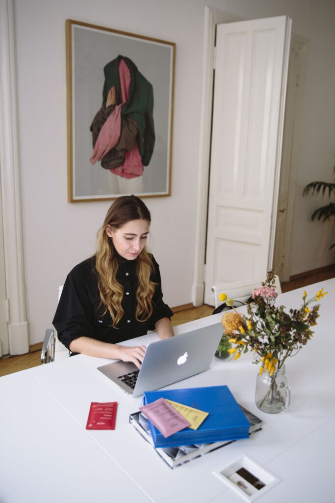 Woman reviewing notes beside a laptop